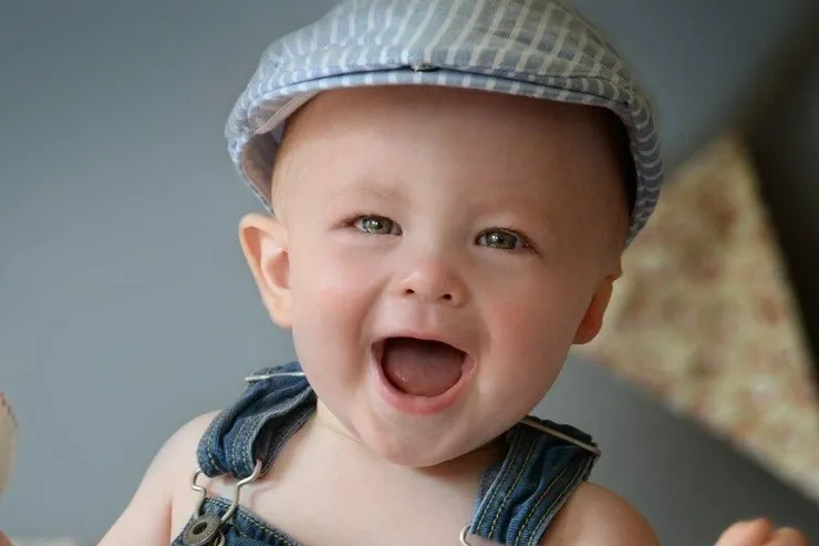 Smiling baby wearing a hearing device