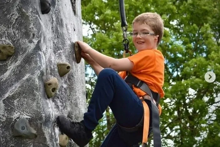 Boy rock climbing on group program