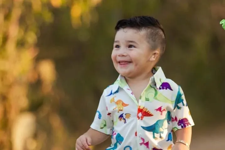 Young boy with microtia in dinosaur shirt